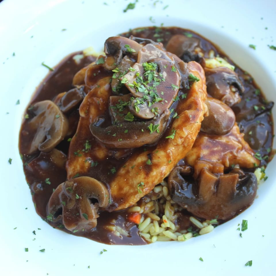 Chicken with mushroom sauce over rice.