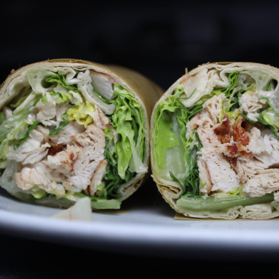 Chicken and lettuce wrap cut into two halves.
